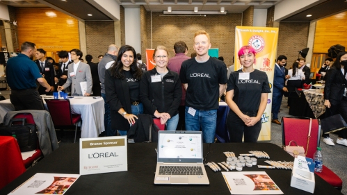 Students standing behind a table at a convention