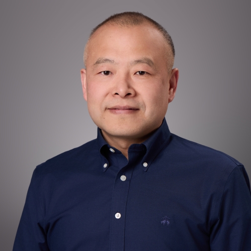 Headshot of male with dark blue button down dress shirt.