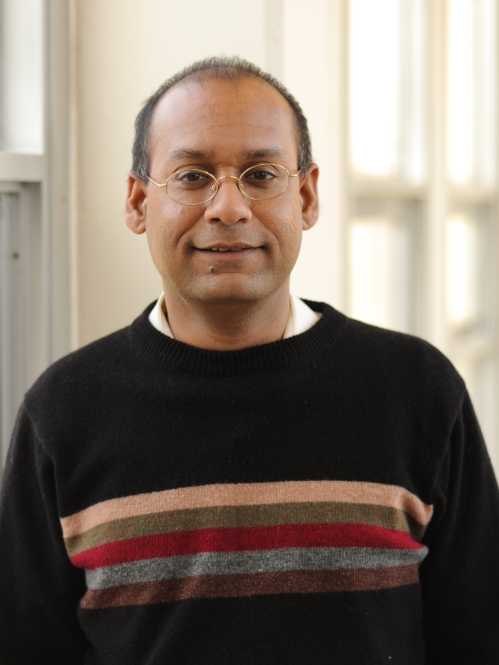 Head shot of male with eyeglasses and short hair, wearing a black pullover sweater.
