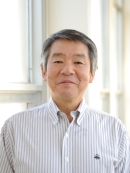 Head shot of Asian male wearing a white patterned button down shirt.