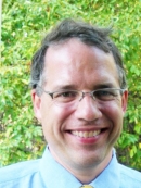 Head shot of male with short hair and eyeglasses.